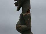 a close up of a wooden statue on a white surface