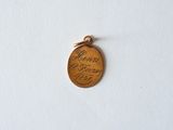 a close up of a wooden medal on a white surface