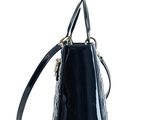 the small black purse is sitting on a white surface