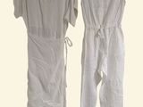 pair of white jumpsuits hanging on a hanger on a white background