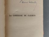 un livre ouvert, sur lequel figure un titre écrit à la main, posé sur une table