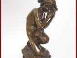 statue en bronze représentant un homme assis sur un livre, la main posée sur le visage