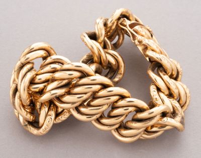 an image of a close up of a gold bracelet on a white surface