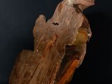 a close up of a wooden sculpture of a person sitting on a log