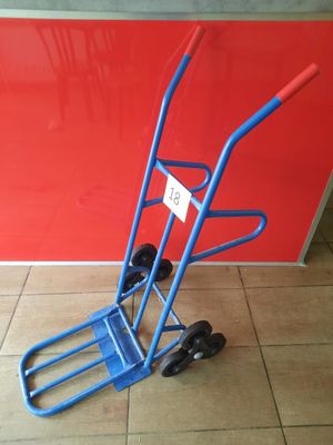 a blue hand truck that is sitting on the floor
