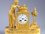une horloge en or surmontée d'une statue