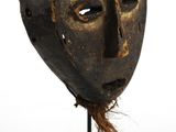 une image d'un masque en bois sur un support