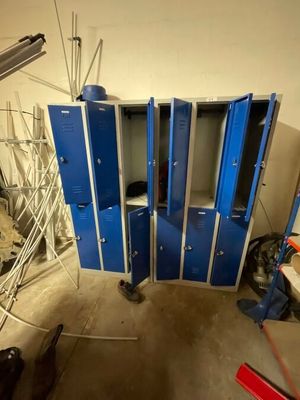 several blue lockers in a room that is being remodeled