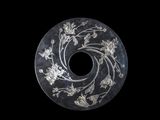 a black and white picture of a circular object with flowers on it