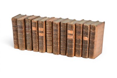 six vieux livres empilés sur une surface blanche