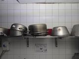 many pots and pans on a shelf in the kitchen