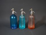 three bottles with soap and lotion on a gray surface