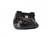 le sac à main noir est posé sur une surface blanche