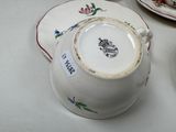 a cup and saucer sitting on a table next to a plate