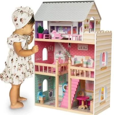 La maison de poupées est en bois et a un toit rose.