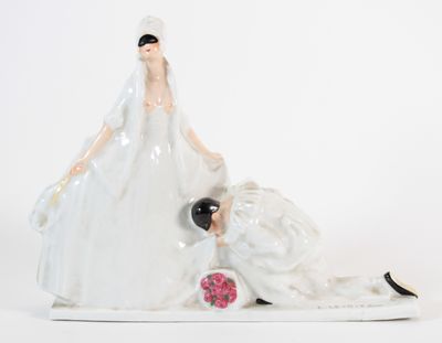une figurine représentant un couple de jeunes mariés allongés par terre