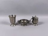 three pieces of silverware sitting on top of a white surface