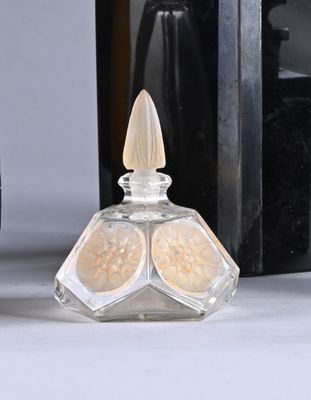 a bottle of perfume next to a bottle of perfume on a table