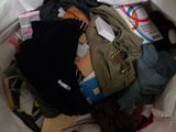 a white bag full of clothes and other items in it