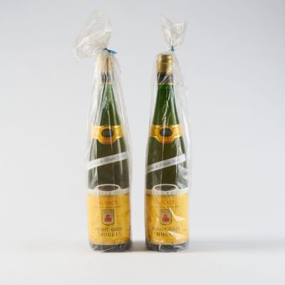 deux bouteilles de champagne emballées dans des sacs en plastique, posées sur une surface blanche