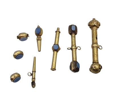 plusieurs objets en laiton et en verre bleu posés sur une surface blanche