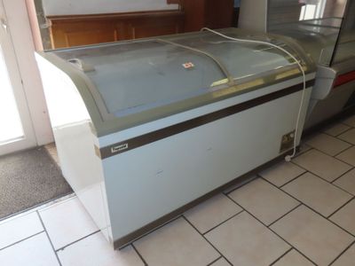 une vitrine en verre au milieu d'un sol carrelé