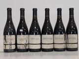 six bouteilles de vin sont alignées sur une table