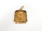 un gros plan d'un pendentif plaqué or représentant le visage d'une femme