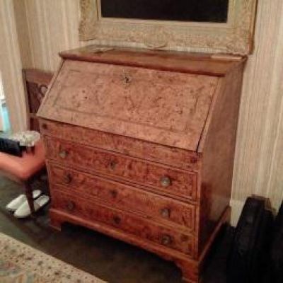 a small wooden desk with a mirror on top of it