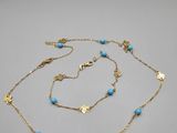 une chaîne en or ornée de perles de turquoise et d'un pendentif en forme d'étoile de mer