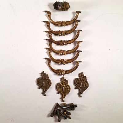 plusieurs éléments de quincaillerie en laiton ancien sur une surface blanche