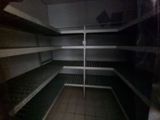 an empty refrigerator with shelves in the middle of it