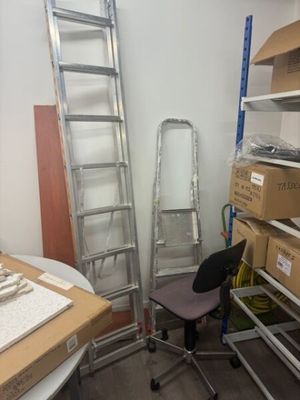 a ladder leaning against a wall next to a chair