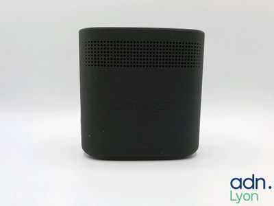 a close up of a black speaker on a white surface