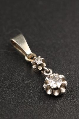 un gros plan d'un pendentif en diamant posé sur une surface noire