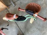 a small child ' s bike with a basket on the handlebars