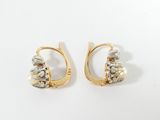 a pair of gold and silver earrings with pearls