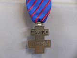 une médaille ornée d'une croix et portant l'inscription « France libre »