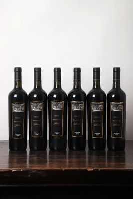 six bouteilles de vin sont alignées sur une table en bois