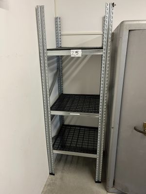 une étagère en métal dans une pièce où se trouve un réfrigérateur