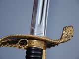 a close up of a sword with a gold handle