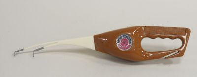 a bottle opener with a handle on a white table