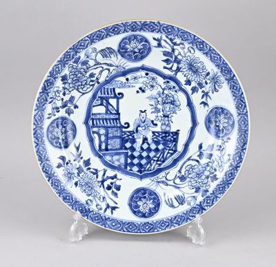 une assiette bleue et blanche sur laquelle est représenté un homme dans un bateau