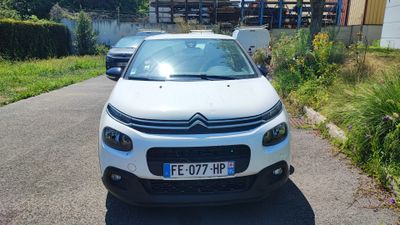 a small white car parked on the side of the road