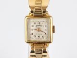 an image of a gold plated wrist watch with a black leather band