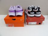 two pairs of puma sneakers are on a box on a table