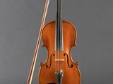 an old violin with a bow and bow rest on a stand