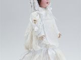 porcelain doll of a young girl in a white dress and veil