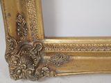 a picture of a gold picture frame on a white surface