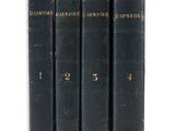 une pile de quatre livres posés les uns sur les autres sur une surface blanche